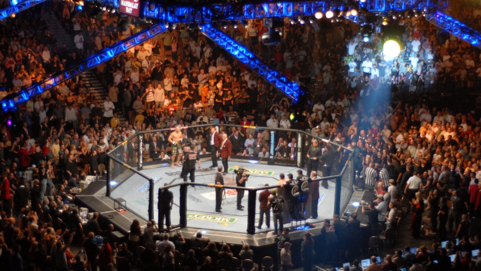 Fans surround the UFC Octagon under blue lights at Mandalay Bay Events Center in Las Vegas