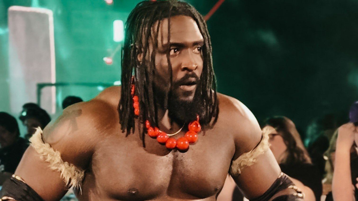 Oba Femi walking to the ring in a red bead necklace and fur armbands, October 2024