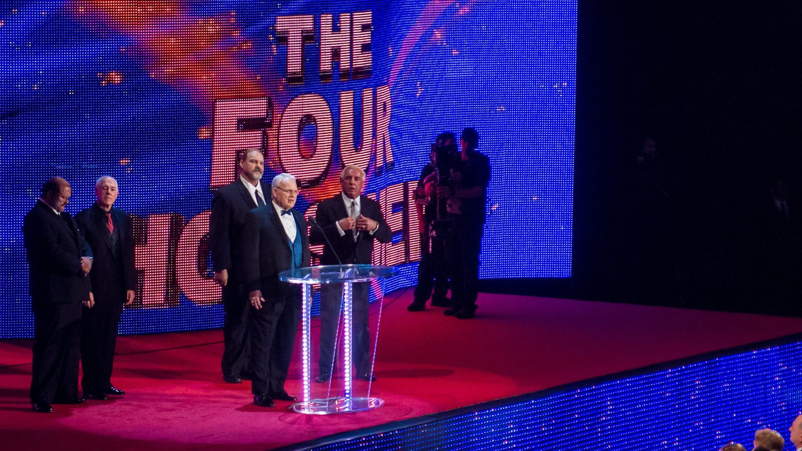 The Four Horsemen on stage at their WWE Hall of Fame induction in Miami in March 2012, with the group's name on the screen behind them